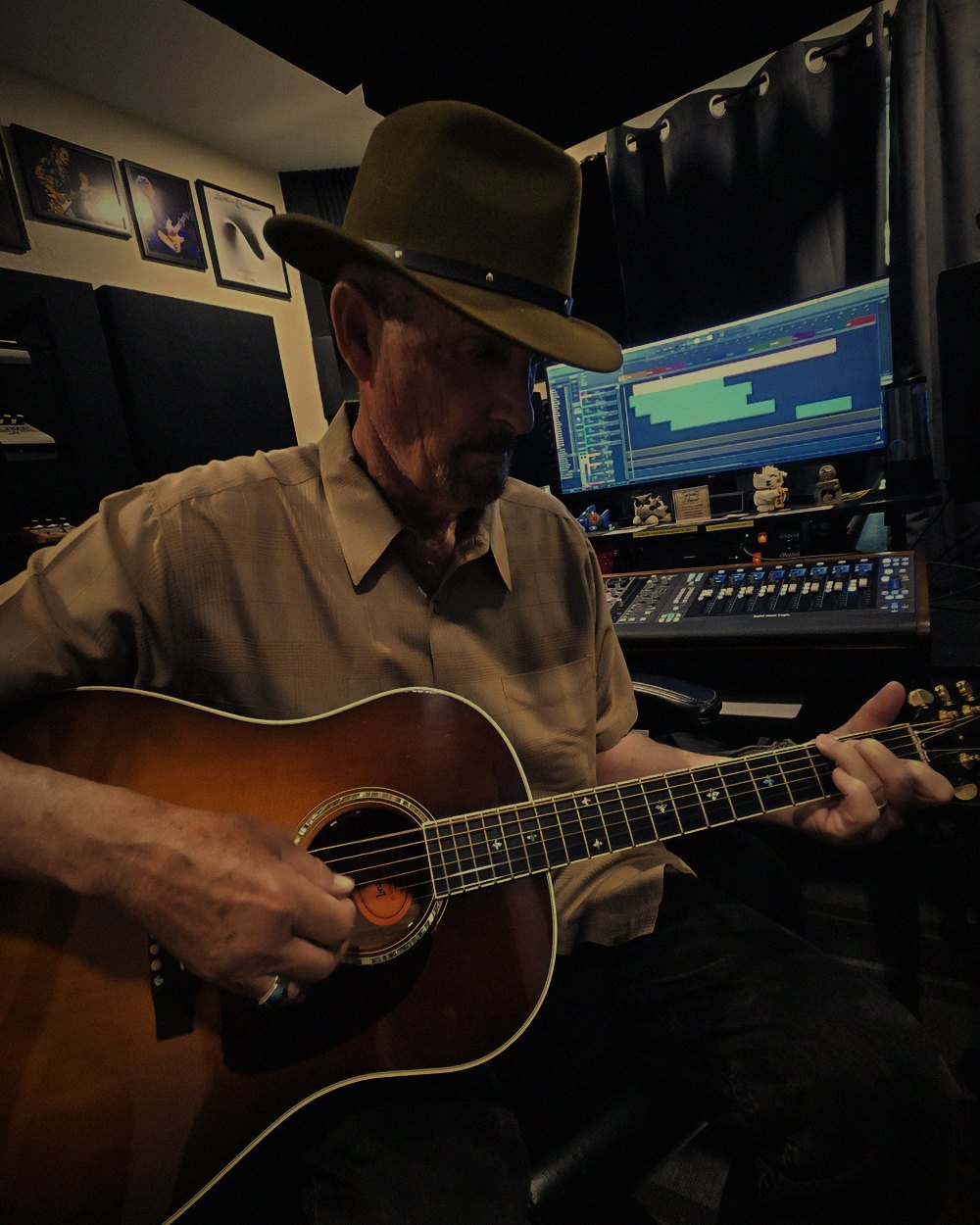 StevieG playing acoustic guitar in the studio